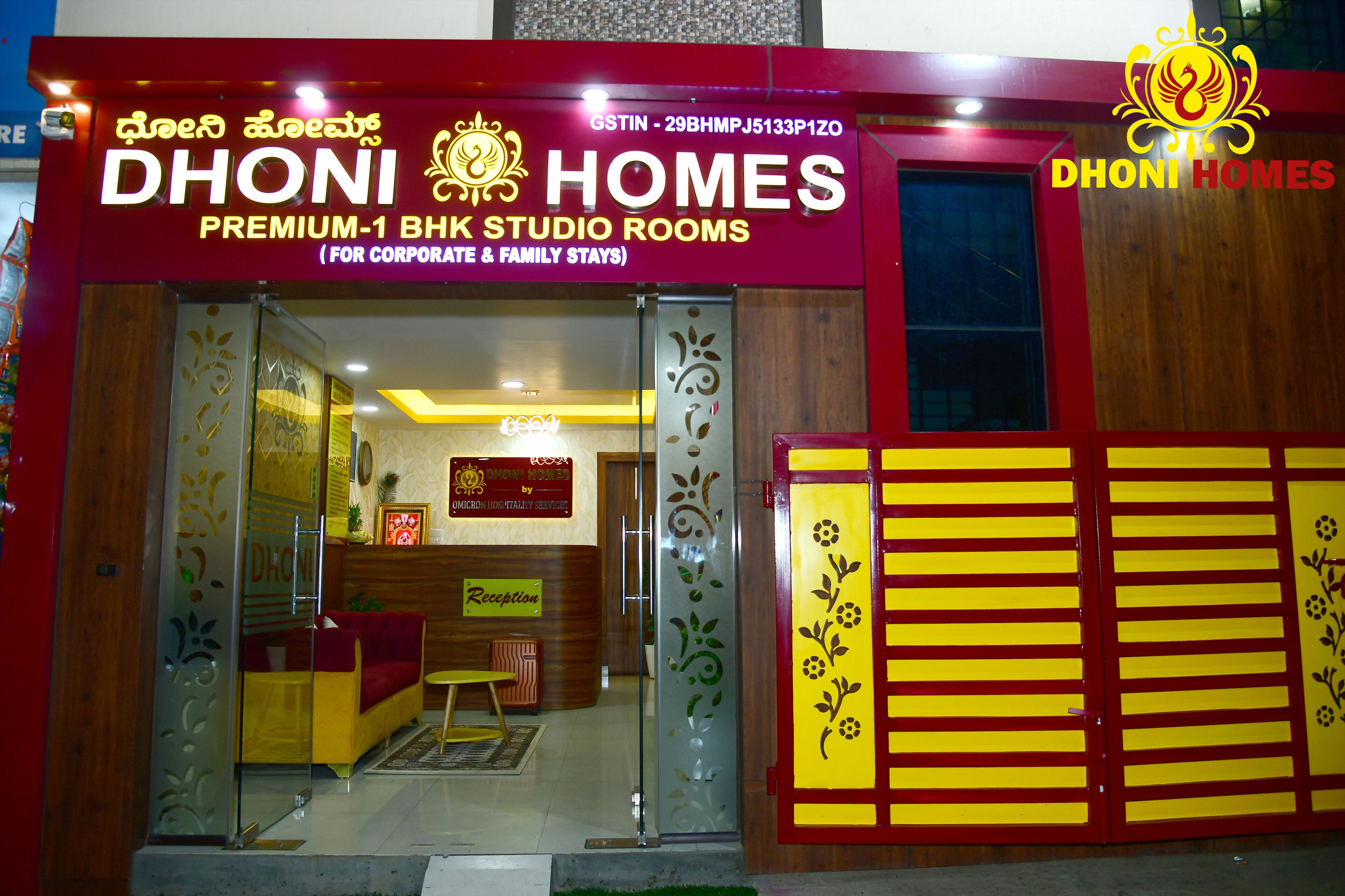 L'esterno di DHONI HOMES, un hotel con area reception e insegna che indica offre camere studio 1-BHK di pregio per soggiorni di lavoro e per famiglie.