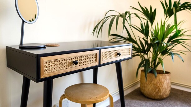 Une coiffeuse avec un miroir, deux tiroirs et un tabouret.