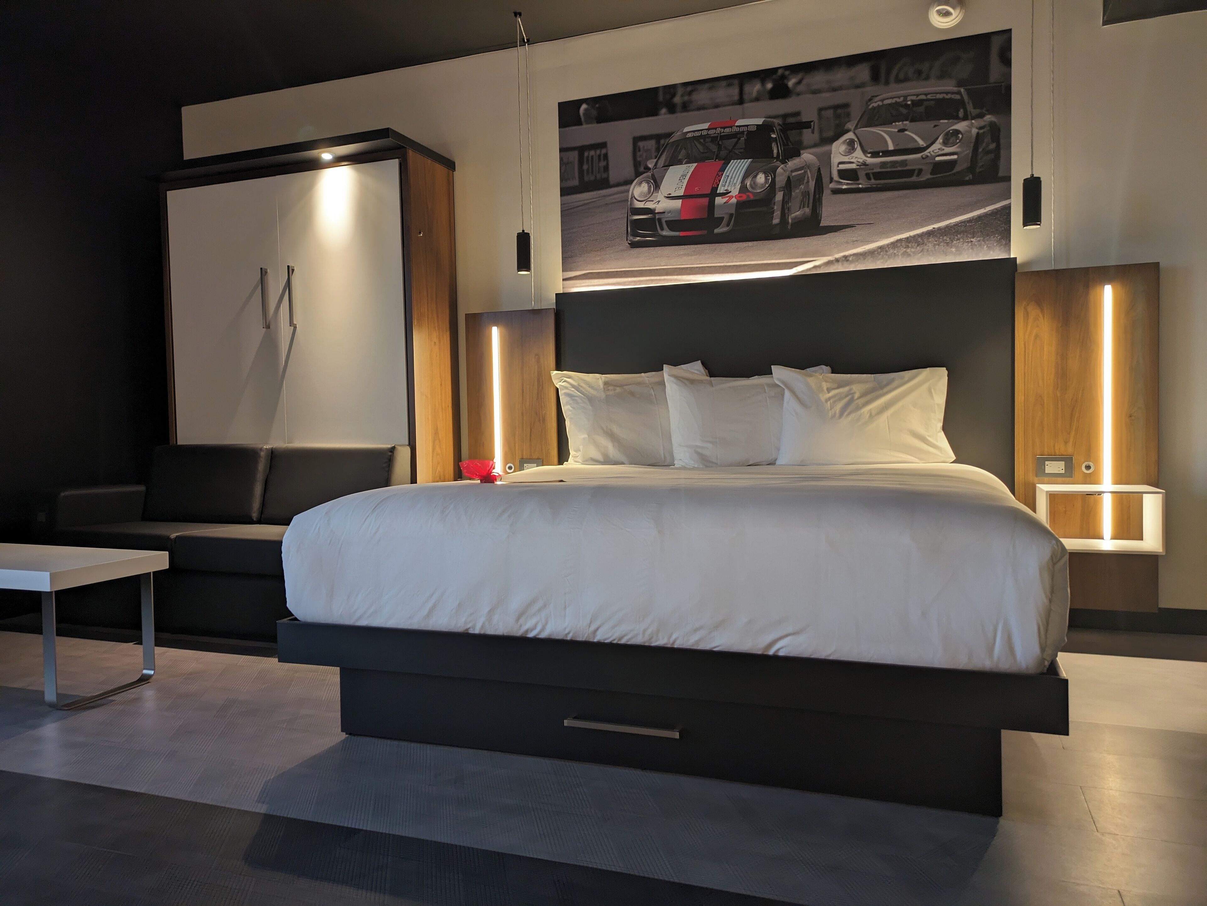A modern hotel room with a large bed, a desk, and a wall-mounted TV.