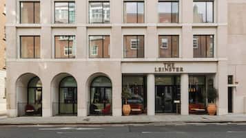 Un edificio de varios pisos con un letrero que dice "The Leinster". Presenta un estilo arquitectónico moderno con ventanas grandes y un techo plano.