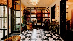 A lobby with a black and white patterned floor, a chandelier, and a sign reading "Collins Club". - The Leinster (Dublin)