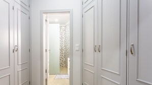 A hallway with white doors, a patterned shower area, and a light-colored floor. - Charming 3-bed House in Funchal (Funchal)