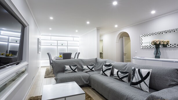 A modern living room with a grey sectional sofa, white coffee table, and a flat-screen TV. - Charming 3-bed House in Funchal (Funchal)