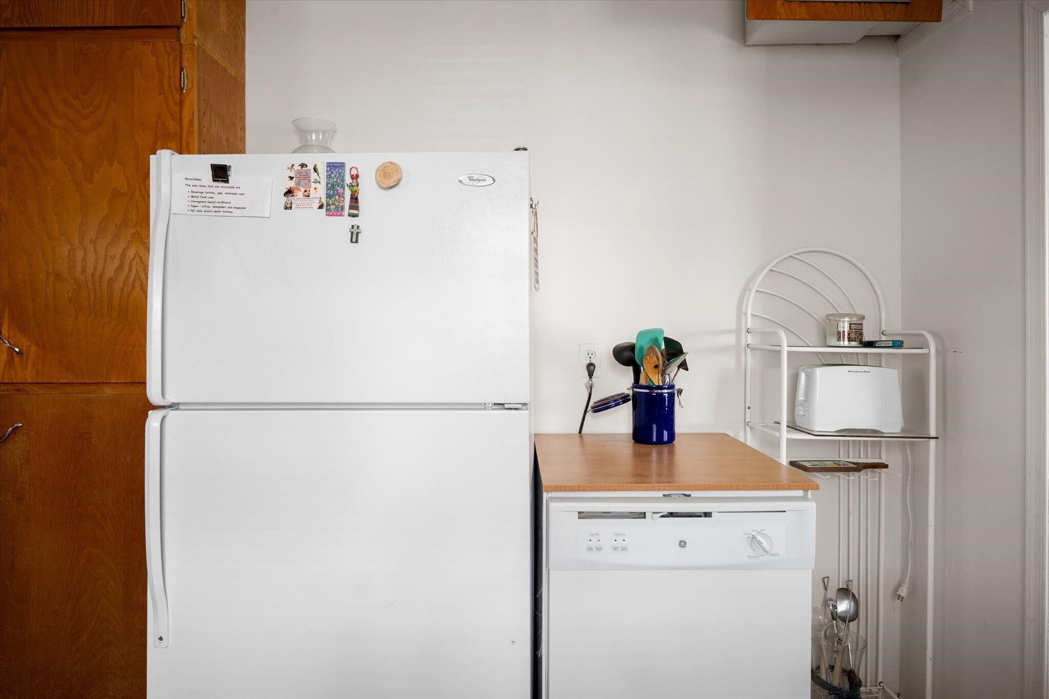 Une cuisine avec un réfrigérateur blanc, un lave-vaisselle et un plan de travail en bois.