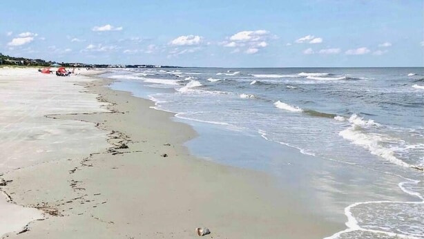 A beach with a sandy shore, waves, and a clear sky. - Updated New Luxury Vacation Condo w New Kitchen Bikes & Beach Gear included (Hilton Head Island)