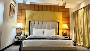 A hotel room with a large bed, two bedside tables with lamps, a headboard, and a curtain. - Panorama Hotel and Spa (Manama)