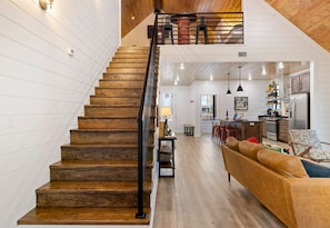A staircase leading to a loft area with a kitchen and living space below. - Private Pool Retreat for Families and Groups (Broken Bow)