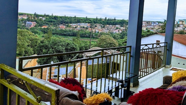 Un balcon donnant sur la ville et la verdure.