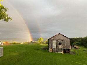 A rustic barn in a grassy field with a rainbow in the background. - New Listing! Remodeled log farmhouse with lake view! (Huntingdon)