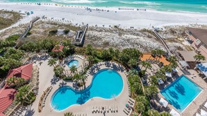 An aerial view of a resort with multiple swimming pools, a beach, and a boardwalk. - Beachfront ~ Private Balcony ~ Golf Cart (Miramar Beach)