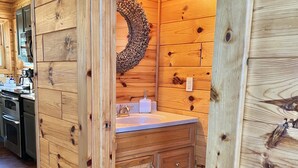 A wooden interior with a wooden wall, a sink, and a rug. - Private & secluded beach front on Lake Huron! (Cheboygan)