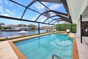 A swimming pool with a view of a marina and houses in the background. - Direct Boating Access | Waterfront Home w/ Pool/Spa (Marco Island)