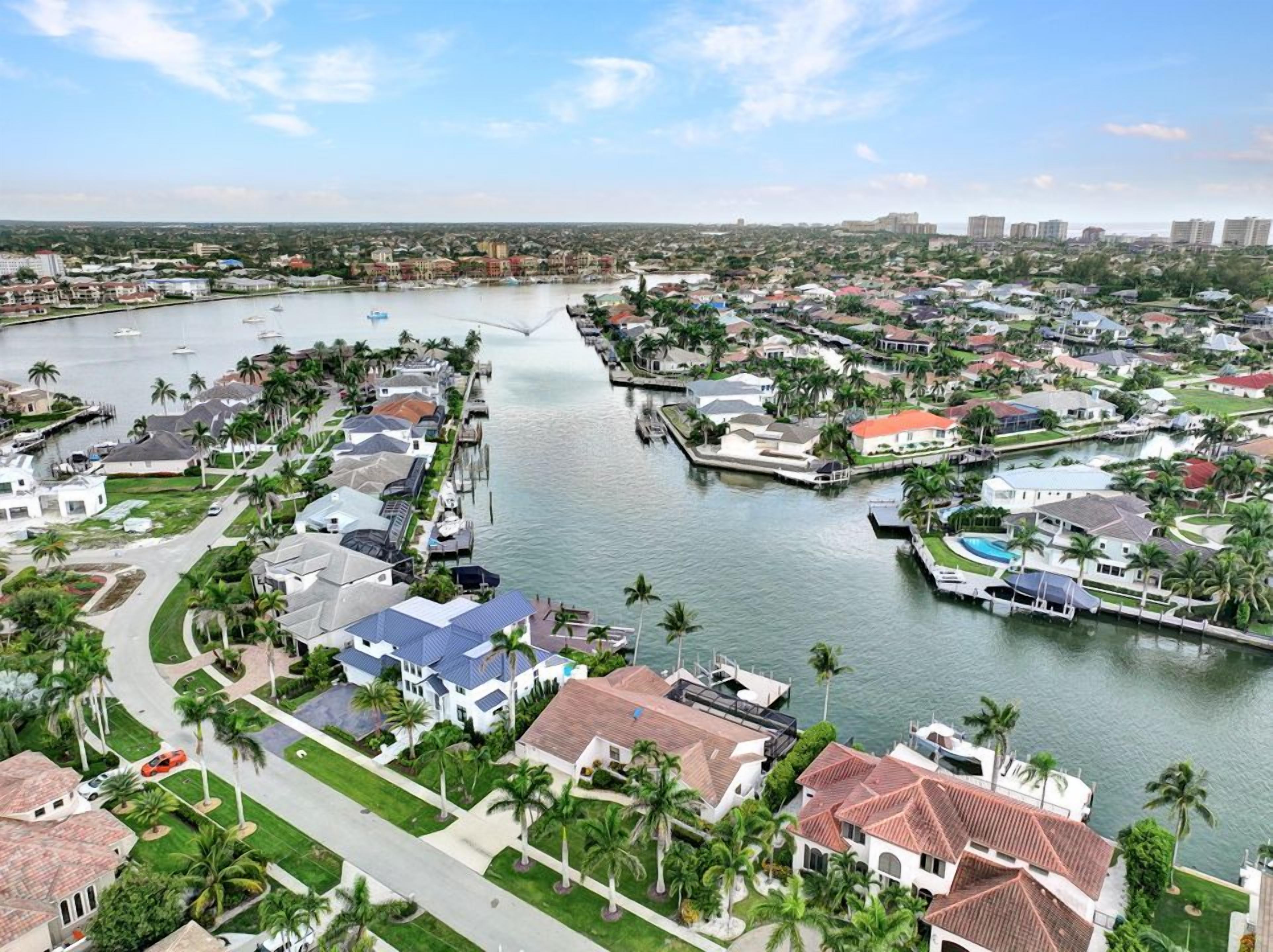 Vue aérienne d’un quartier résidentiel avec des maisons, un port de plaisance et une rivière.