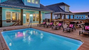 Un espace piscine avec des chaises longues et une terrasse en bois.