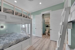 Habitación con literas y una puerta que da a un baño.