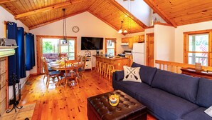 A cozy cabin interior with a dining area, kitchen, and living room. - Beautiful Bluebirds and Star Studded Skies Surround! 
EV Charge / Pet Friendly! (Galena Territory)