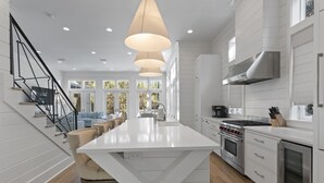 A modern kitchen with white cabinetry, a central island, and stainless steel appliances.