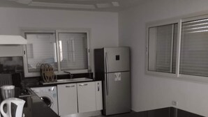 Una cucina moderna con mobili bianchi, un piano di lavoro nero e elettrodomestici in acciaio inossidabile.