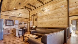 A cozy cabin interior with a wooden ceiling, a sofa, a dining area, and a kitchen. - Ern806 - Splashin' Views 2 Bedroom Cabin by RedAwning (Sevierville)