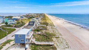 Une ville côtière dotée de propriétés en bord de mer, d’une promenade et d’une plage de sable.