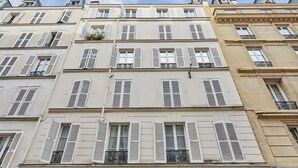 A multi-story building with white facades and shutters, featuring balconies with wrought iron railings. - Superb & New Studio Eiffel Tower (Paris)