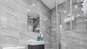A modern bathroom with a toilet, sink, and glass-enclosed shower. - Impeccable Ensuite Room in Finsbury Park Londonn19 (London)