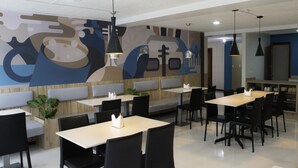 Un interior de restaurante con cabinas, mesas y lámparas colgantes.