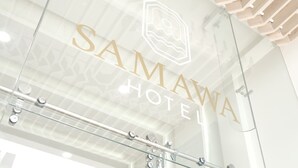 Un letrero de hotel con el nombre 'SAMAWA HOTEL' y un logotipo encima.
