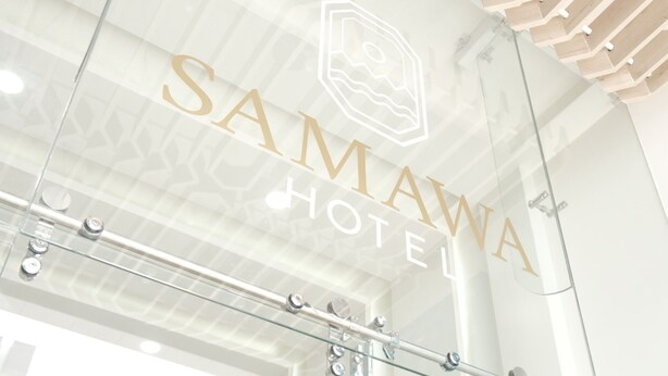 Ein Hotelschild mit dem Namen "SAMAWA HOTEL" und einem Logo darüber.