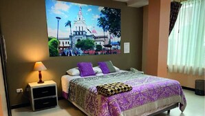 Un dormitorio con cama, mesita de noche, lámpara, un cuadro colgado en la pared y una ventana con cortinas.
