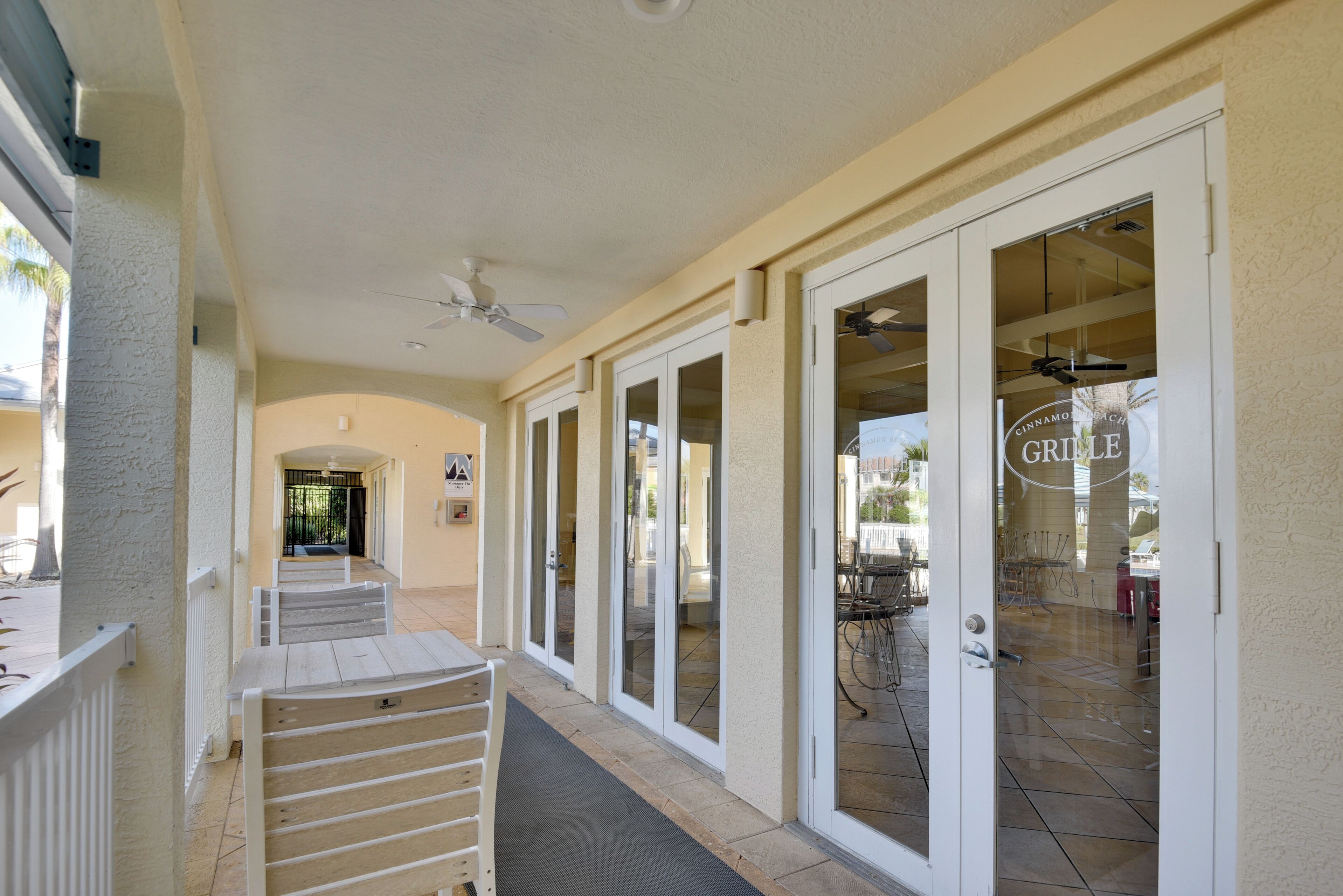 A covered outdoor corridor with sliding glass doors leading to a patio area.