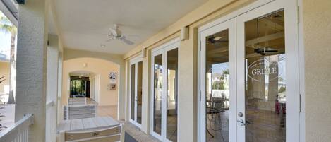 A covered outdoor corridor with sliding glass doors leading to a patio area.