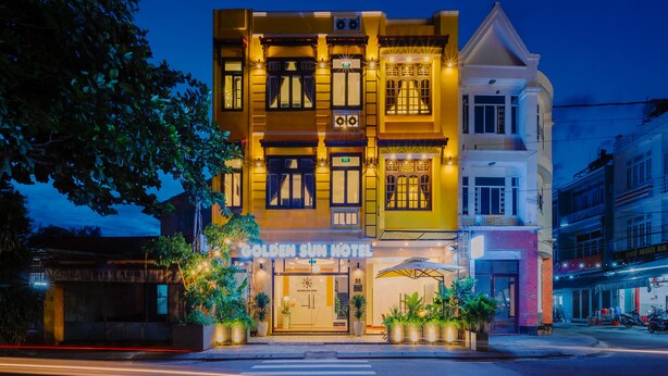 A hotel with a traditional facade, large windows, and a sign reading "Golden Sun Hotel". - Golden Sun Hotel Hoi An (Da Nang)