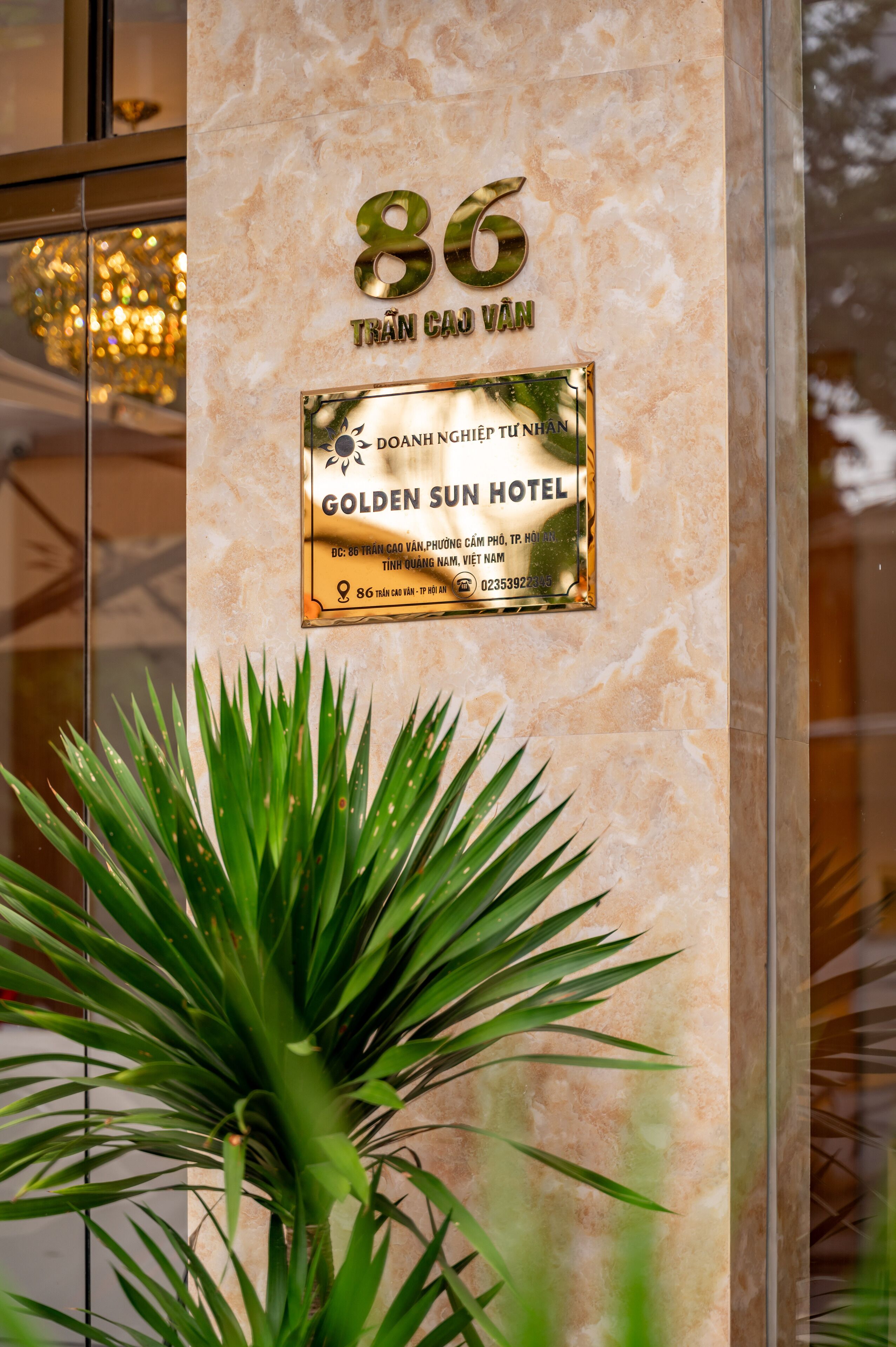 Un letrero de hotel con el número 86 y el nombre 'Golden Sun Hotel' sobre una pared de mármol.