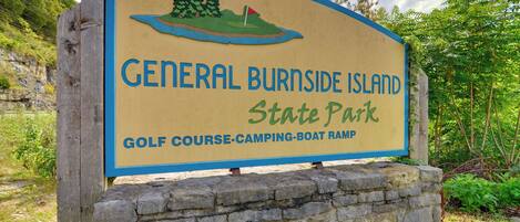 Bord voor General Burnside Island State Park dat de voorzieningen benadrukt: golfbaan, camping en een aanlegsteiger voor boten.