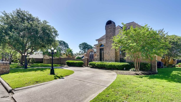 A residential area with a brick house, a curved driveway, and well-maintained lawns. - Expansive Home w/ Pool Table ~ 15 Mi to Galveston! (Texas City)