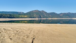 A wide, open landscape with a large body of water reflecting the surrounding mountains.