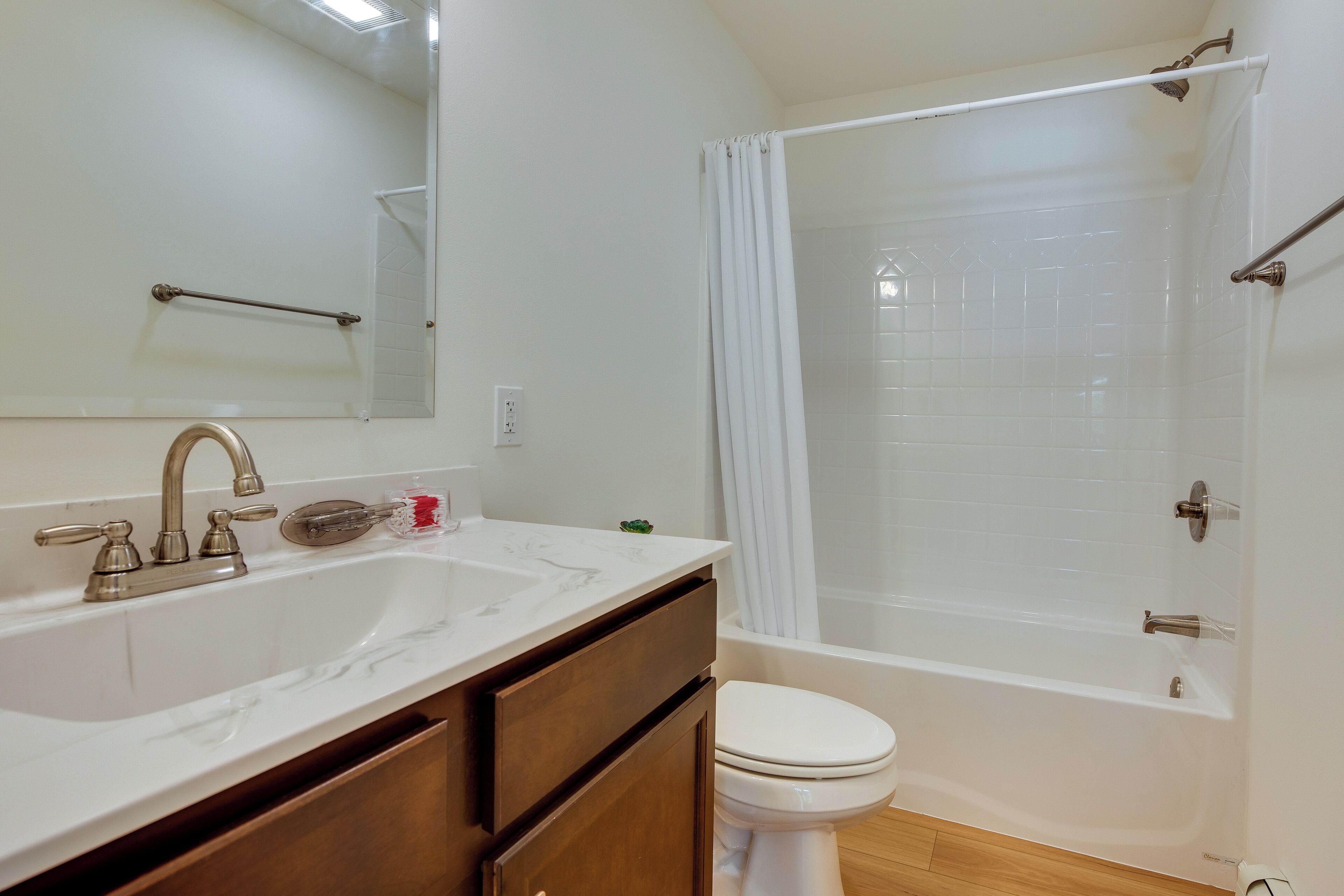 Une salle de bain équipée d’un lavabo, d’un miroir, de toilettes et d’une baignoire.