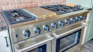 A stainless steel range with a brick wall background and a built-in oven. - Family-friendly Utah Home: Deck, Mountain Views! (Vernal)