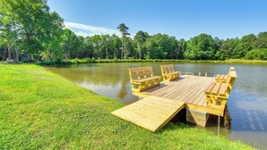 A wooden dock extending into a lake surrounded by lush greenery and trees. - Waterfront Benson Retreat: Rescue Farm w/ a Lake! (Benson)