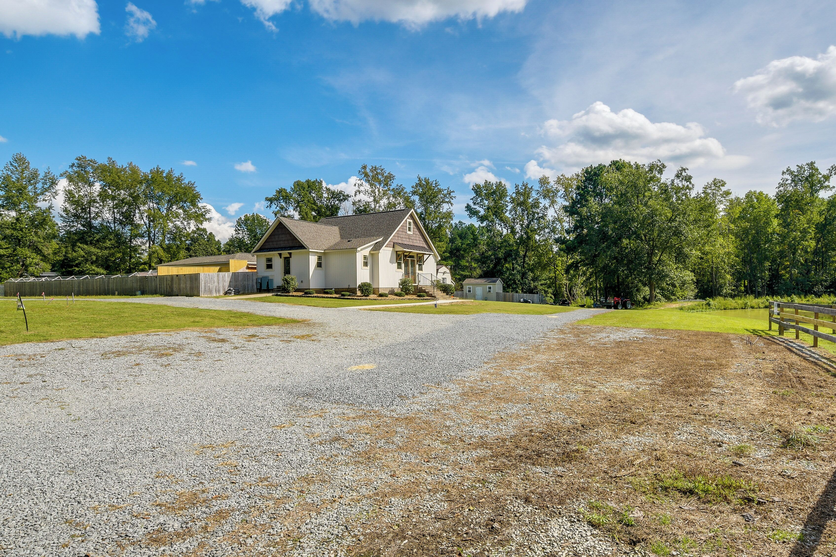 A house with a gravel driveway and a fenced yard.