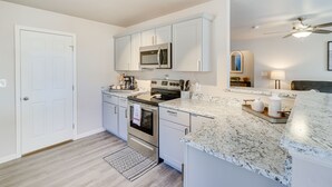 A modern kitchen with white cabinets, stainless steel appliances, and a granite countertop. - Gold Canyon Vacation w/ Private Patio & Fire Pit! (Gold Canyon)