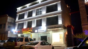 A multi-story hotel with a visible entrance and a sign for a restaurant. - SALSBIL AL ALMASI HOTEL (Madinah)