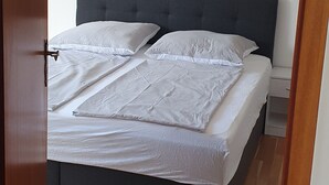 Une chambre à coucher avec un lit, une table de chevet et un plancher en bois.