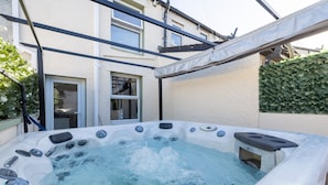 A hot tub in a backyard with a pergola overhead. - Morecambe Bay Cottage- Hot Tub/ Jacuzzi/sauna (Morecambe)
