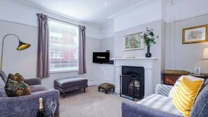 A living room with a fireplace, a television, and a sofa.
