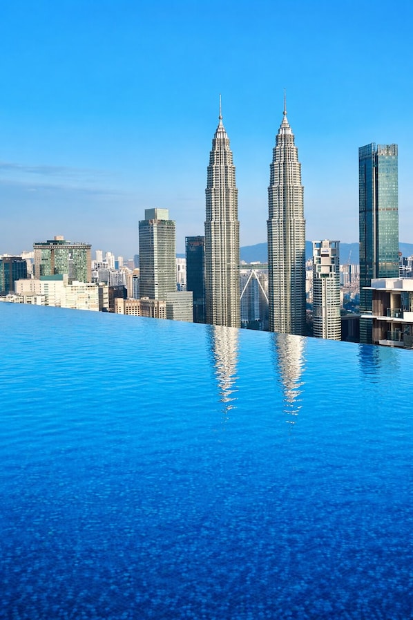 Un paysage urbain avec des gratte-ciel modernes et un grand bassin d’eau dont la surface est réfléchissante.