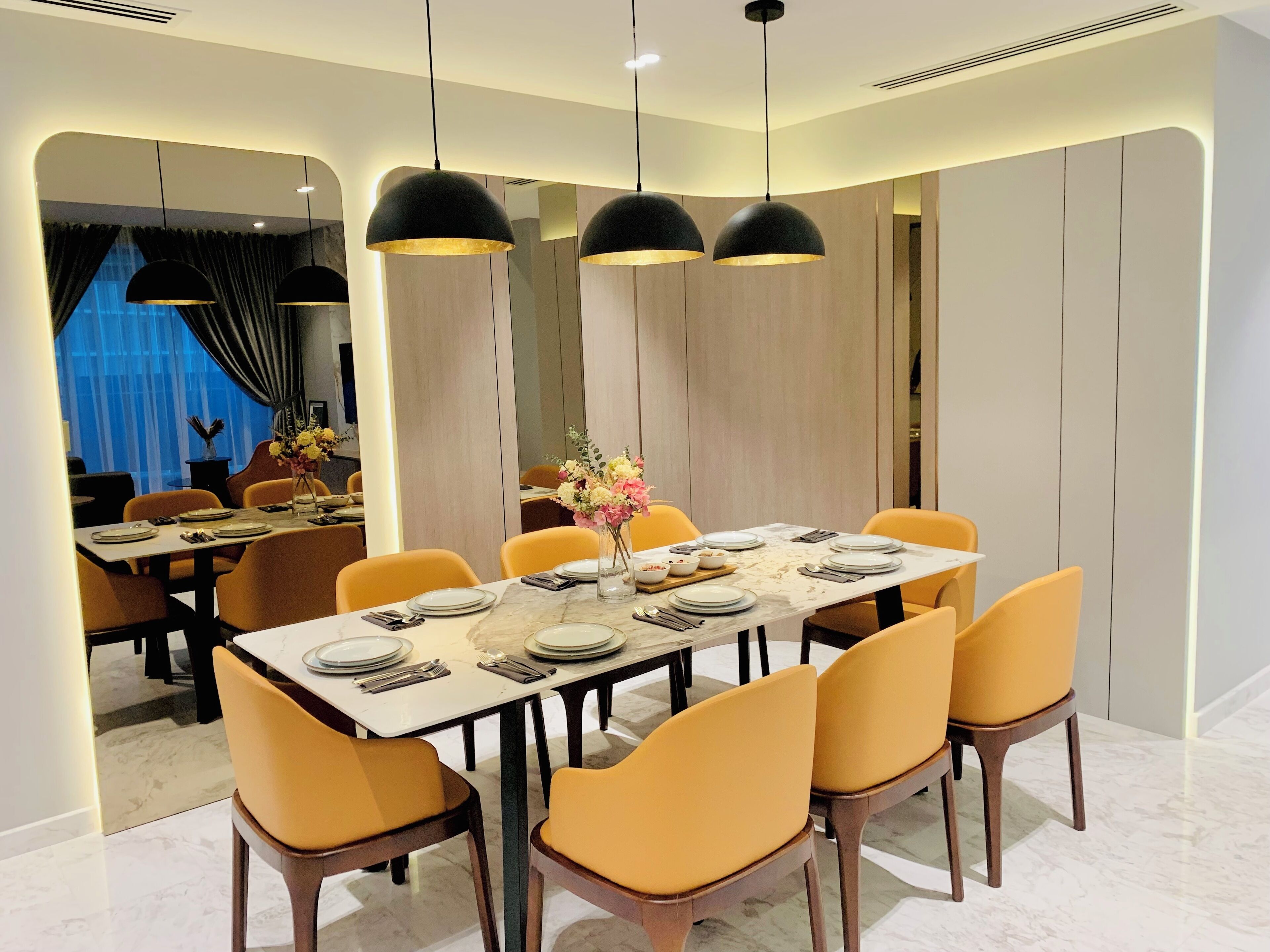A modern dining area with a rectangular table set for six, surrounded by yellow chairs.