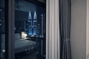 Une chambre avec vue sur les tours Petronas, de nuit.