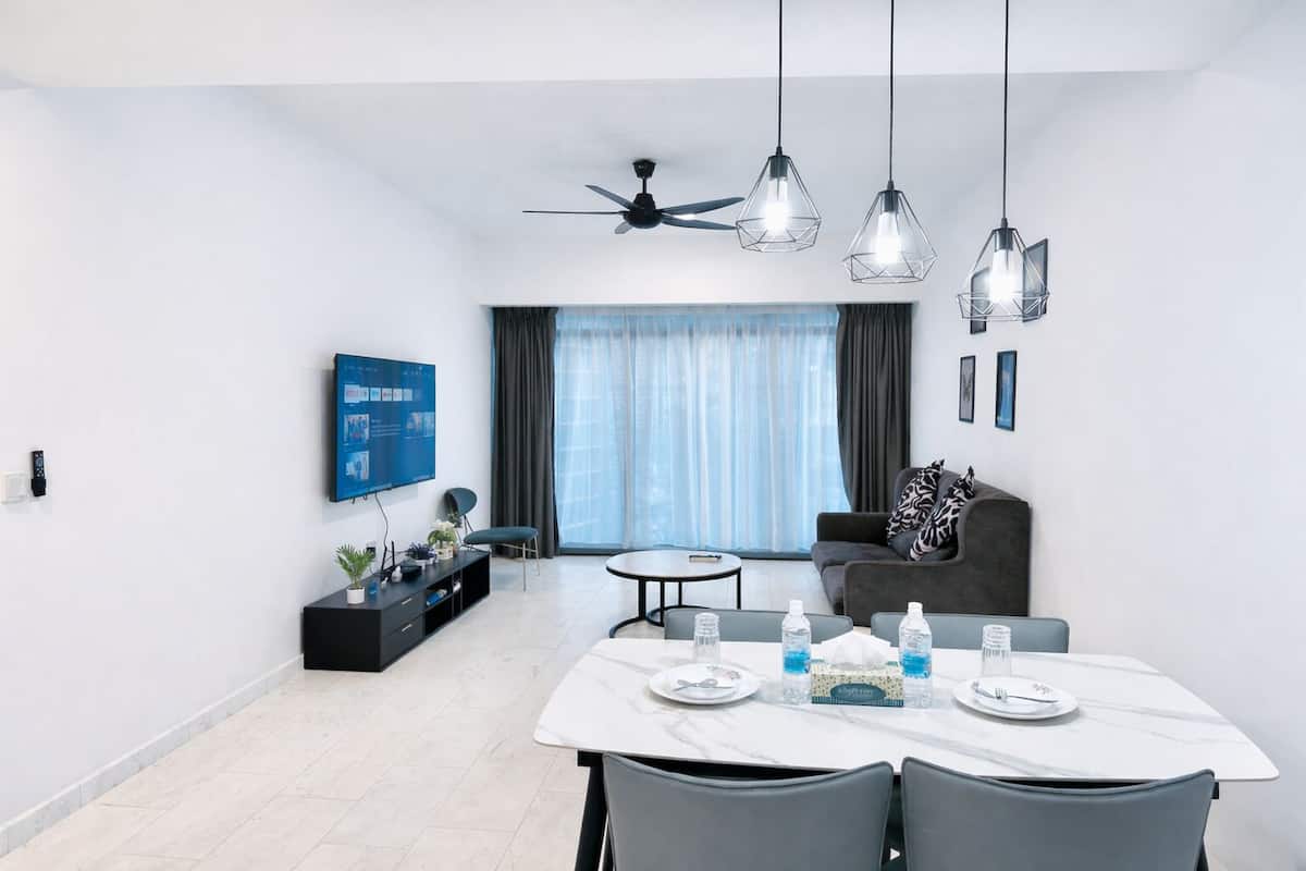 A modern living room with a dining area, a ceiling fan, and pendant lights.